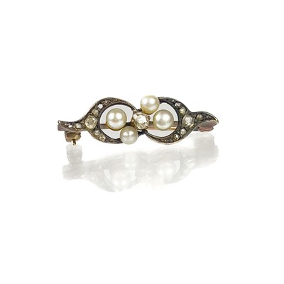 Lot 265 - A Edwardian rose gold diamond and pearl set scroll brooch.