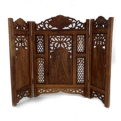 Lot 1021 - An Indian wood carved three fold table screen with brass mounts.