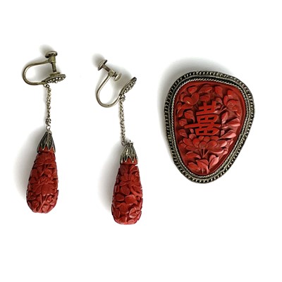 Lot 306 - A Chinese cinnabar lacquer and white metal brooch and earrings, circa 1900.