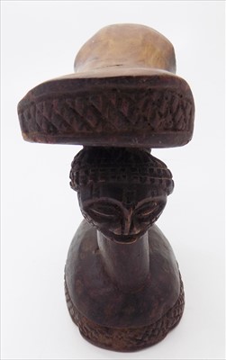 Lot 184 - An African carved wood tribal headrest.