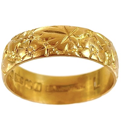 Lot 189 - A 22ct hallmarked gold band ring with foliate engraved decoration.