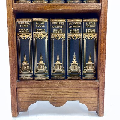 Lot 1877 - The works of Charles Dickens contained in a small oak bookcase.