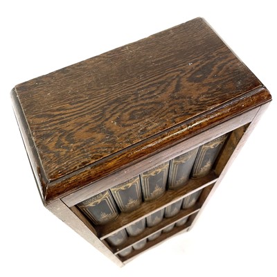 Lot 1877 - The works of Charles Dickens contained in a small oak bookcase.