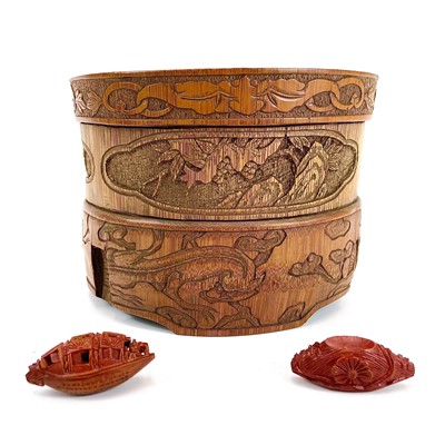 Lot 421 - A Chinese carved heidao nut carved as a sampan with calligraphy to the base and a resin stand.