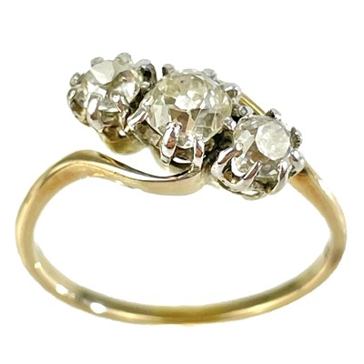 Lot 157 - An early 20th century 18ct gold diamond set three stone crossover ring.