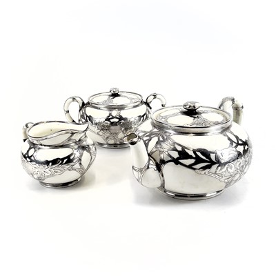 Lot 832 - A Royal Doulton white glazed silver overlaid three-piece tea service.