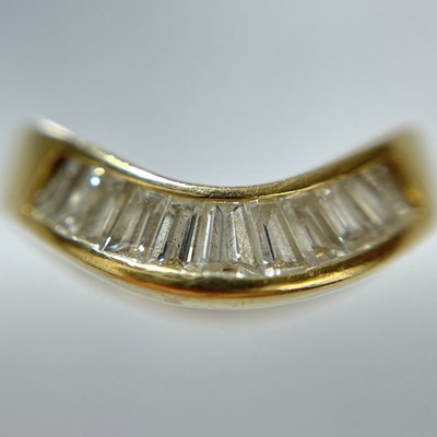 Lot 21 - A high purity gold diamond set eleven stone wishbone ring.