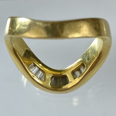 Lot 21 - A high purity gold diamond set eleven stone wishbone ring.