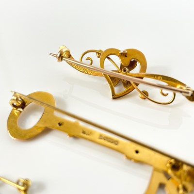 Lot 275 - A 1940's 15ct bar brooch and a 9ct key design '21' bar brooch.