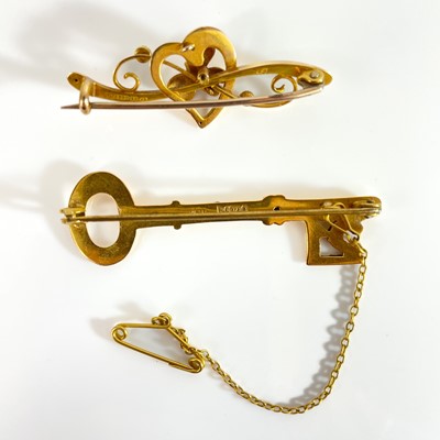 Lot 275 - A 1940's 15ct bar brooch and a 9ct key design '21' bar brooch.