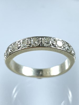 Lot 231 - An 18ct white gold diamond set nine stone half eternity ring.