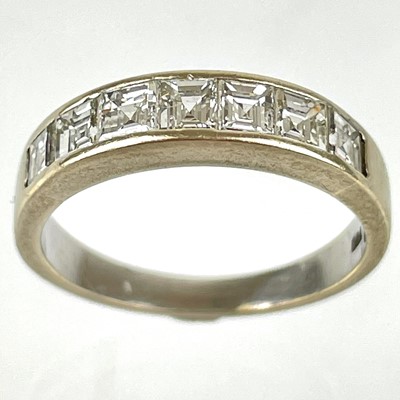 Lot 57 - An 18ct white gold diamond square cut set seven stone half eternity ring.