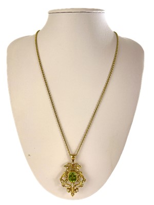 Lot 357 - An Art Nouveau high purity gold (tests 14ct) peridot and seed pearl set brooch pendant.