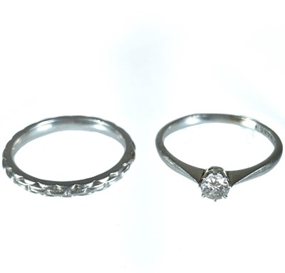 Lot 366 - A platinum (tested) diamond solitaire ring and a platinum (tested) band ring.