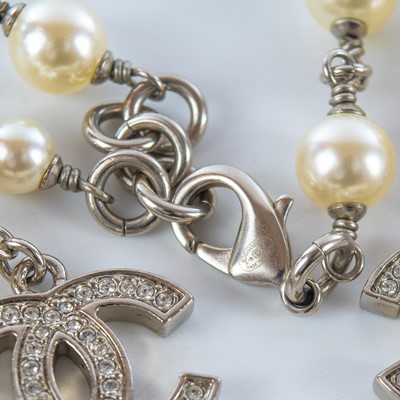 Lot 559 - A Chanel white metal cultured pearl and white gem set CC long necklace.