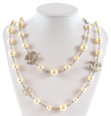 Lot 139 - A Chanel white metal cultured pearl and white gem set CC long necklace.