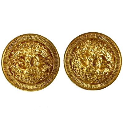 Lot 563 - A Chanel pair of gold plated disc CC clip earrings.