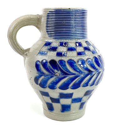 Lot 58 - A saltglaze jug with blue incised feather decoration and chequered borders.