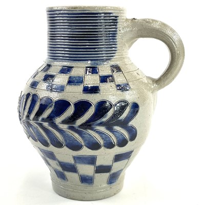 Lot 58 - A saltglaze jug with blue incised feather decoration and chequered borders.