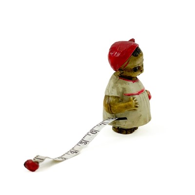 Lot 24 - A celluloid novelty tape measure modelled as a young girl.