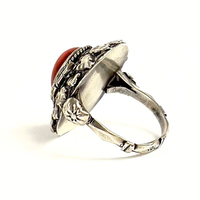 Lot 41 - An 800 silver coral set locket ring.