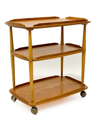 Lot 431 - An Ercol Windsor light elm three tier trolley with lipped edges.