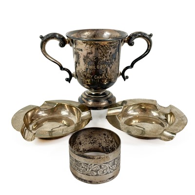 Lot 323 - A silver trophy cup, a pair of silver ashtrays and a napkin ring.