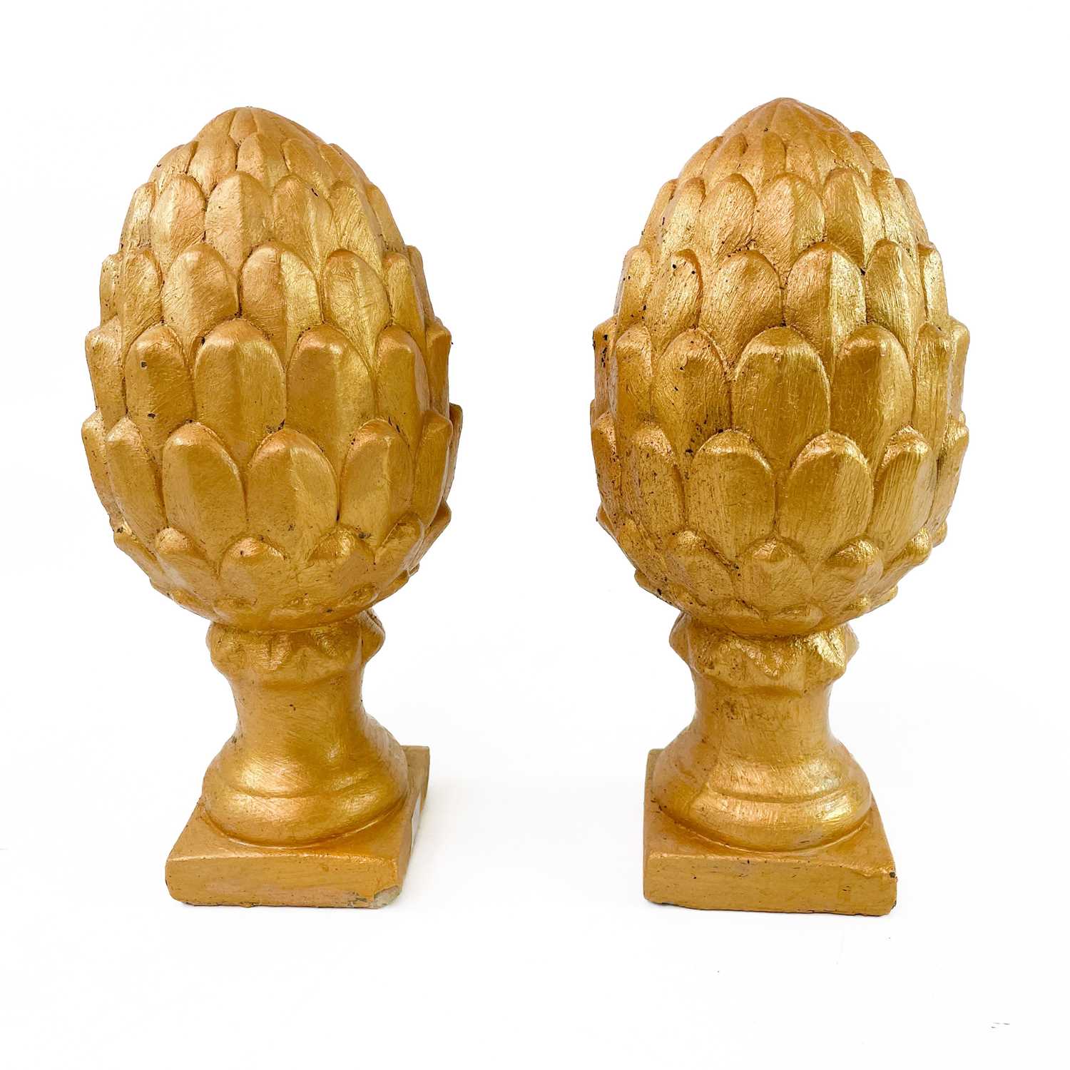 Lot 607 - Pair of stone acorns painted gold.