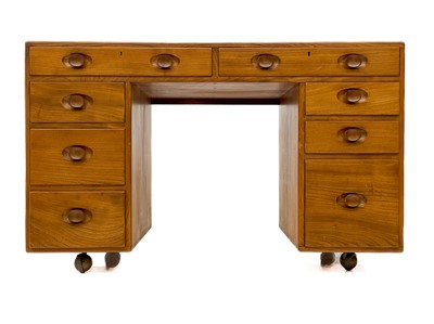 Lot 1856 - An Ercol Windsor light elm kneehole desk.