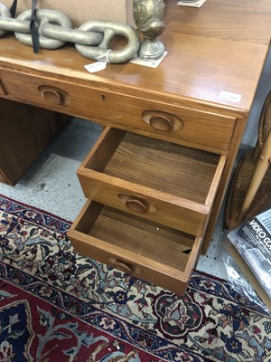 Lot 1856 - An Ercol Windsor light elm kneehole desk.