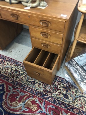 Lot 1856 - An Ercol Windsor light elm kneehole desk.