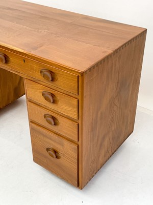 Lot 1856 - An Ercol Windsor light elm kneehole desk.