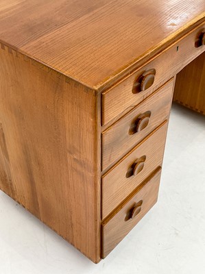 Lot 1856 - An Ercol Windsor light elm kneehole desk.