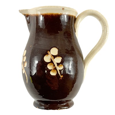 Lot 228 - An early 19th century English pottery sparrow beak  jug in a treacle glaze.