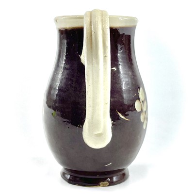 Lot 228 - An early 19th century English pottery sparrow beak  jug in a treacle glaze.