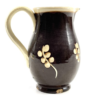 Lot 228 - An early 19th century English pottery sparrow beak  jug in a treacle glaze.