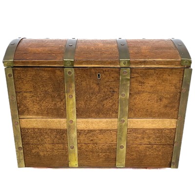 Lot 1909 - An oak and brass bound dome top chest.