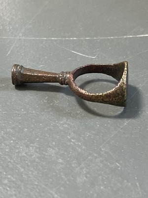 Lot 231 - A 17th century copper-alloy seal and pipe tamper ring.