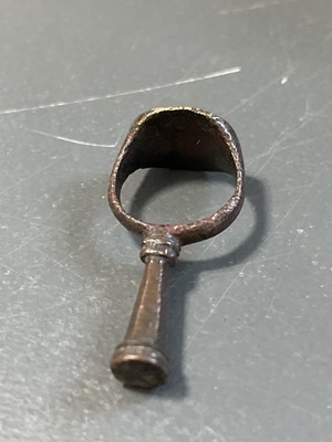 Lot 231 - A 17th century copper-alloy seal and pipe tamper ring.