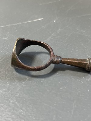 Lot 231 - A 17th century copper-alloy seal and pipe tamper ring.