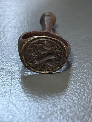 Lot 231 - A 17th century copper-alloy seal and pipe tamper ring.