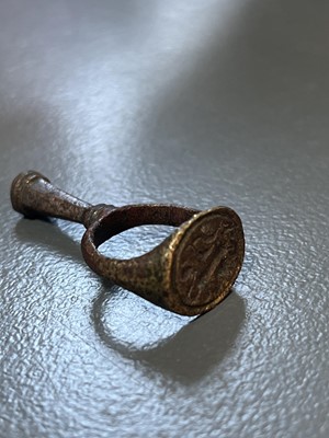 Lot 231 - A 17th century copper-alloy seal and pipe tamper ring.