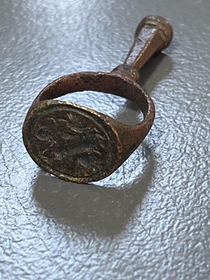 Lot 231 - A 17th century copper-alloy seal and pipe tamper ring.