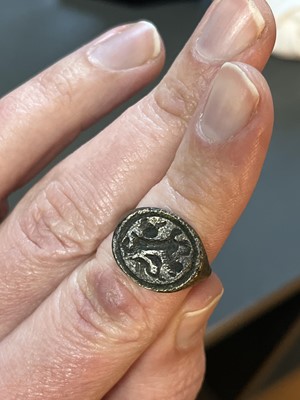 Lot 231 - A 17th century copper-alloy seal and pipe tamper ring.