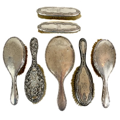 Lot 295 - Six silver backed brushes and a silver backed hand mirror.