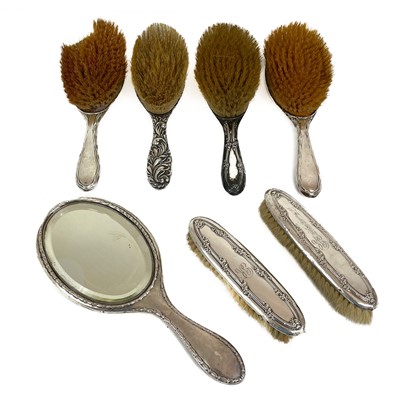 Lot 295 - Six silver backed brushes and a silver backed hand mirror.