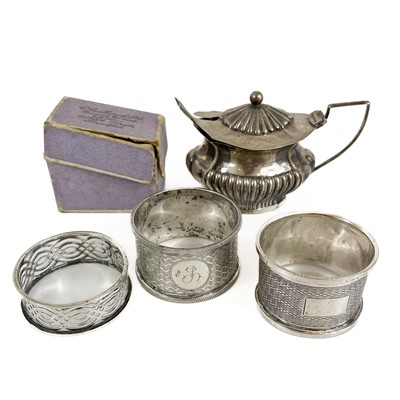 Lot 196 - An Edwardian silver mustard pot and three silver napkin rings .