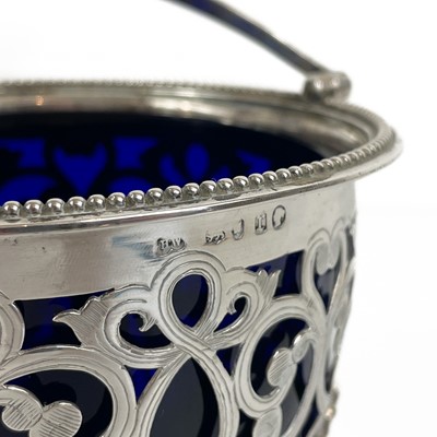 Lot 123 - A Victorian silver swing handled basket with blue glass liner by Henry Wilkinson & son.