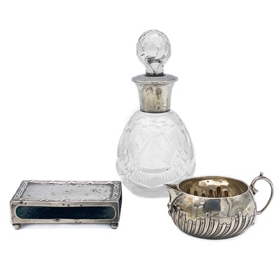 Lot 101 - A Edwardian Silver matchbox holder, a silver cream jug and a glass bottle with silver collar.