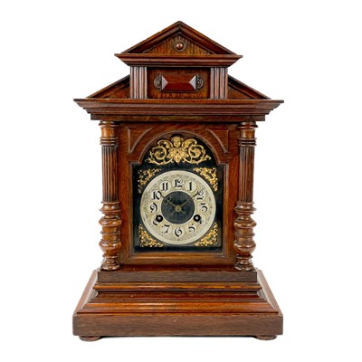 Lot 1710 - A German oak cased quarter striking mantel clock.